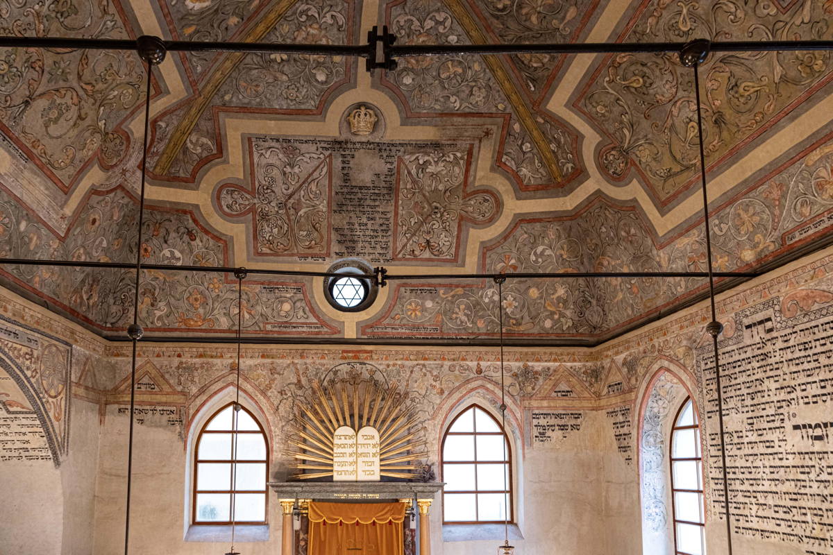 Mural paintings and Hebrew prayers cover the ceilings, vaulted archways, wall